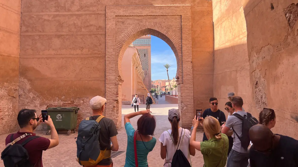 Visitors exploring a historic archway in the Marrakech Medina, one of the best things to do in Marrakech.
