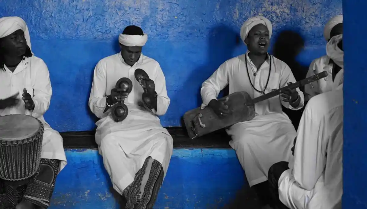 Gnaoua musicians playing traditional instruments in a blue medina in Morocco - 2026 Festival Calendar