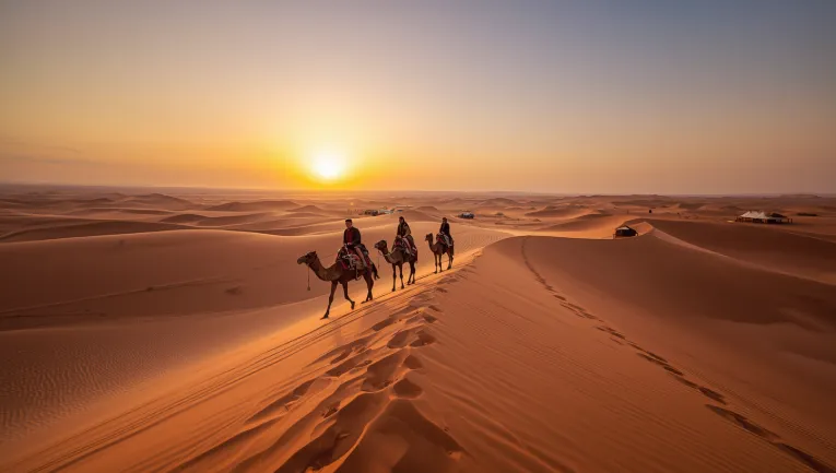 Camel caravan at sunset in the Erg Chebbi dunes during a 4-day Sahara Desert tour from Marrakech
