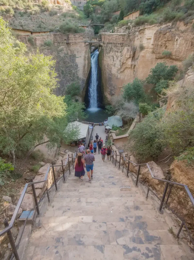 Tourists walking down stone steps on the trail to Ouzoud Falls