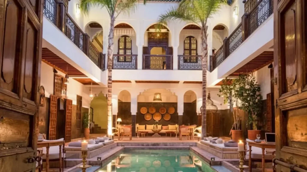 Traditional riad courtyard in Marrakech with fountain and tiled walls. where to stay in Morocco?