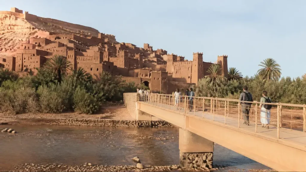 Travelers crossing the pedestrian bridge toward Aït Ben Haddou