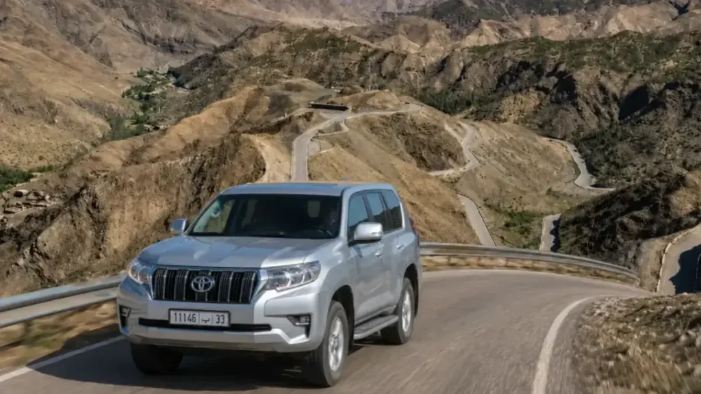 Toyota Prado driving on a winding road through Tizi n'Tichka Pass in the High Atlas Mountains