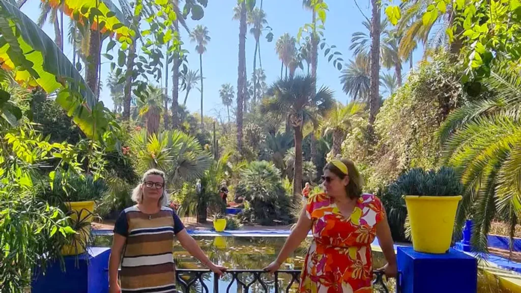 Visitors beside the blue walls and tropical gardens at Jardin Majorelle in Marrakech