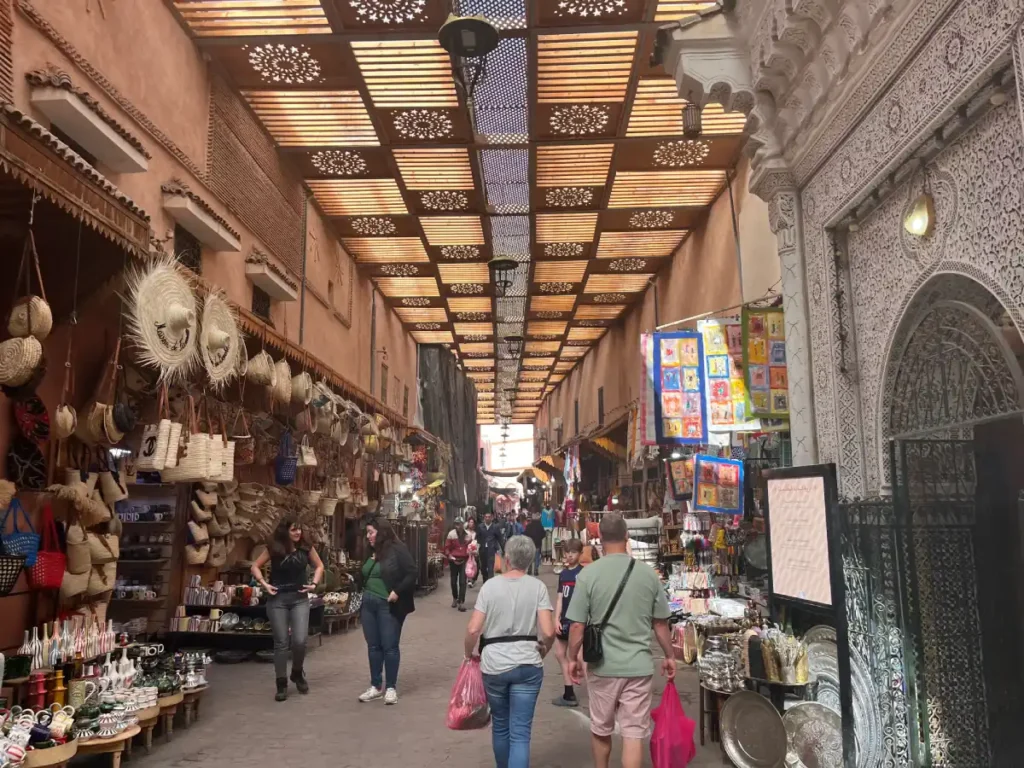 Travelers walking through the covered souks of Marrakech Medina