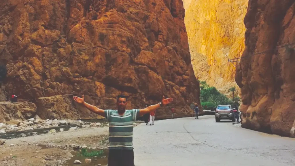 Local guide standing beneath the towering cliffs of Todra Gorge in Morocco