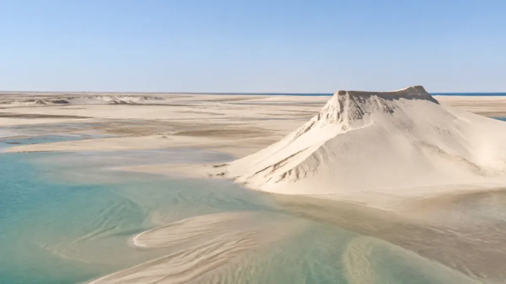 White Dune rising beside the shallow turquoise lagoon near Dakhla