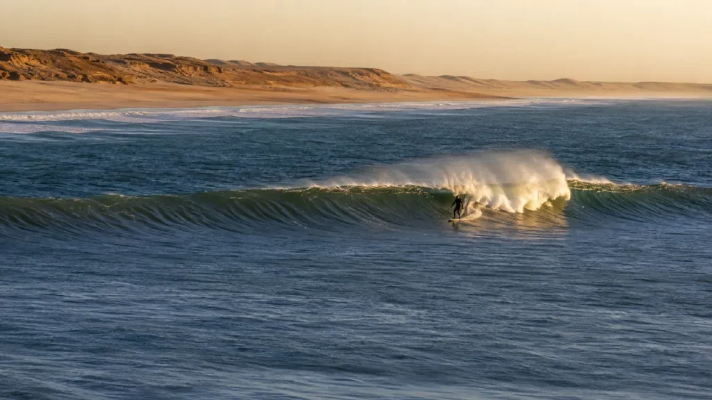 Surfer riding an Atlantic wave at Foum El Bouir near Dakhla