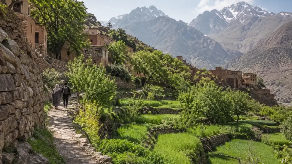 Walkers following a path between Amazigh villages and terraced fields near Imlil