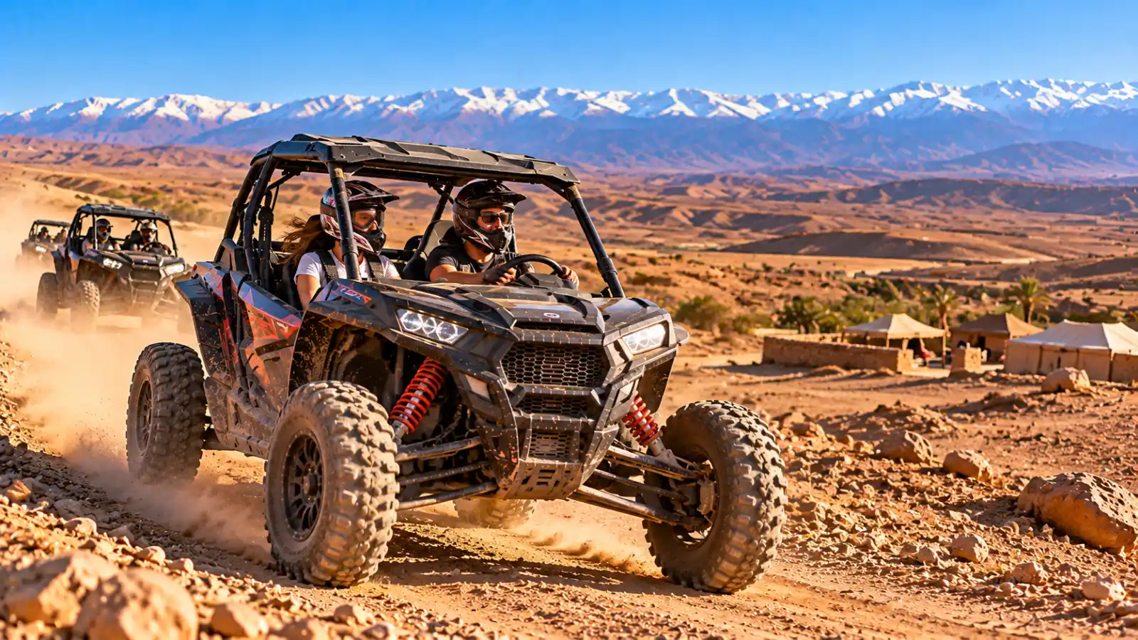 Marrakech buggy tour in Agafay with travelers driving off-road buggies and the Atlas Mountains behind