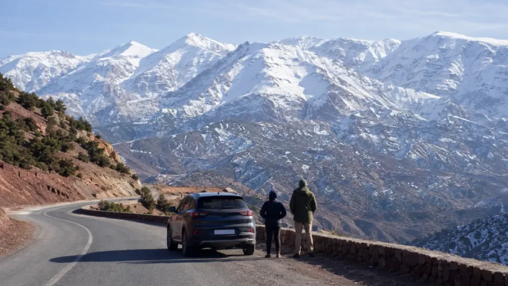 Travelers viewing snow-covered High Atlas Mountains on a January day trip from Marrakech