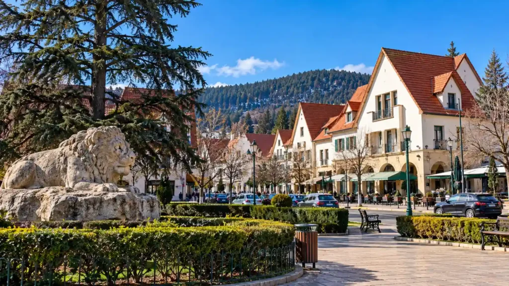 Ifrane Morocco travel guide featuring Alpine-style buildings with red-tiled roofs, outdoor cafés, tree-lined streets and a pedestrian square in the Middle Atlas Mountains.