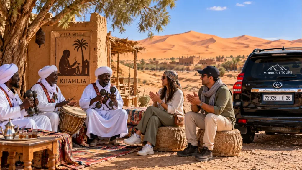 Traditional Gnawa musicians performing in Khamlia near Merzouga with travelers enjoying local music during a Sahara desert tour