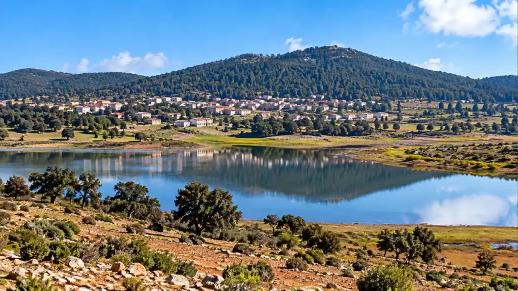 Lake Dayet Aoua in Morocco’s Middle Atlas Mountains with calm water, forested hills and scenic countryside