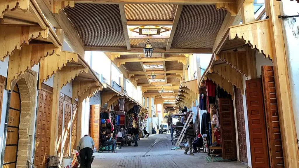 Rue des Consuls in Rabat Medina, showing the traditional covered shopping street, Moroccan artisan shops and wooden lattice canopy.