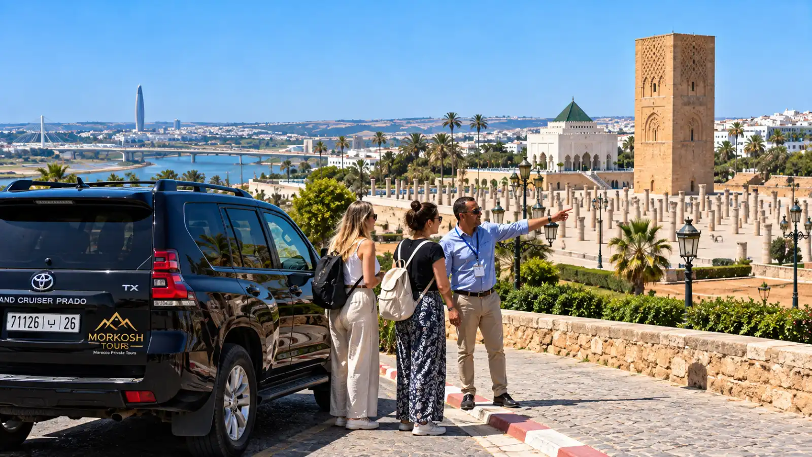 Rabat city tour with a licensed local guide and two visitors overlooking Hassan Tower and the Mausoleum of Mohammed V beside a black Morkosh Tours Toyota Prado TX.