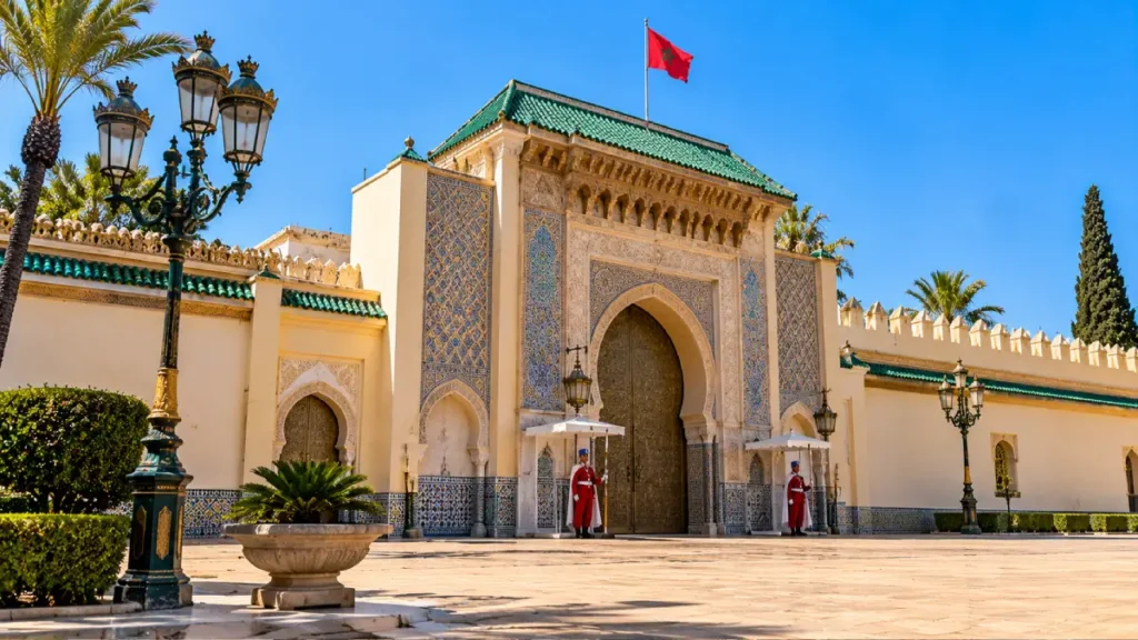 Royal Palace of Rabat entrance with traditional Moroccan zellige tilework, green-tiled roof, ceremonial guards and Moroccan flag.